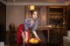 A woman in a red dress holding a bowl of fruit.