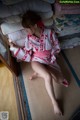 A woman in a red and white kimono sitting on the floor.