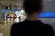 A man standing in front of an exit sign at an airport.