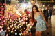 A woman in a blue dress standing in front of a bunch of lights.