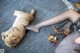 A cat laying on the floor next to a woman's legs.